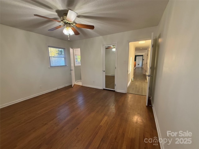 empty room featuring ceiling fan and dark hardwood / wood-style flooring