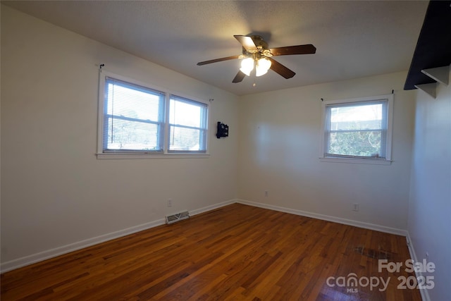 unfurnished room with dark wood-type flooring and ceiling fan