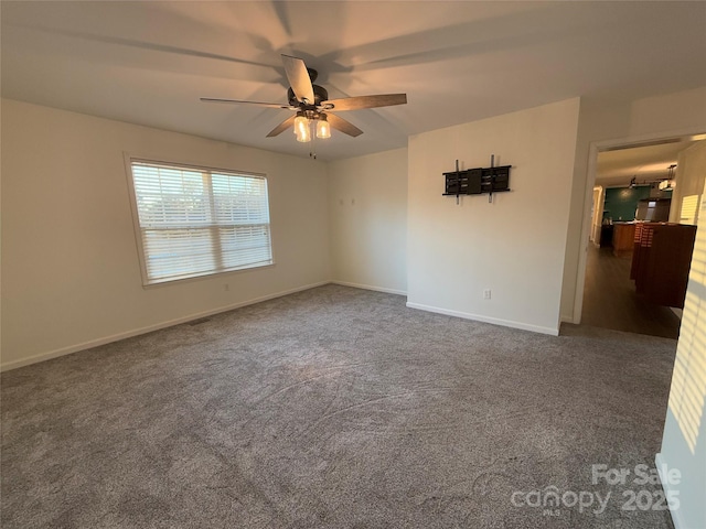 empty room featuring ceiling fan and carpet