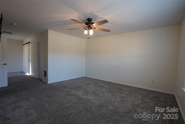 unfurnished room with ceiling fan and dark carpet