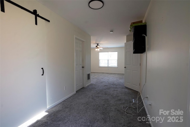 hall with dark colored carpet