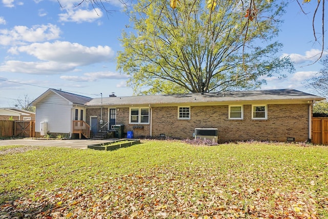 rear view of property with a yard and cooling unit