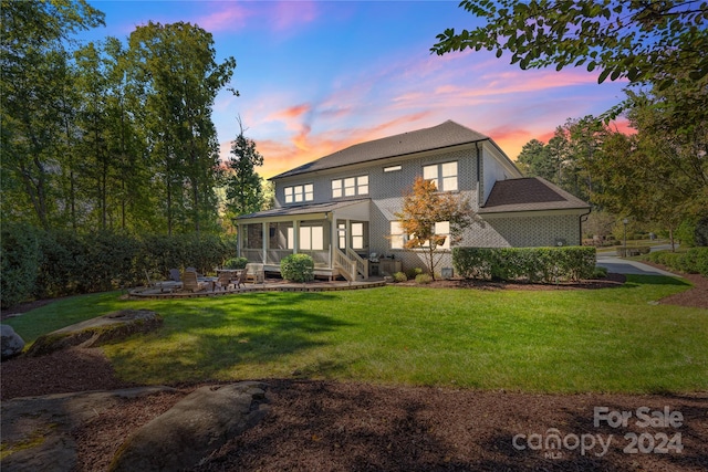 exterior space with a patio, a lawn, and a sunroom