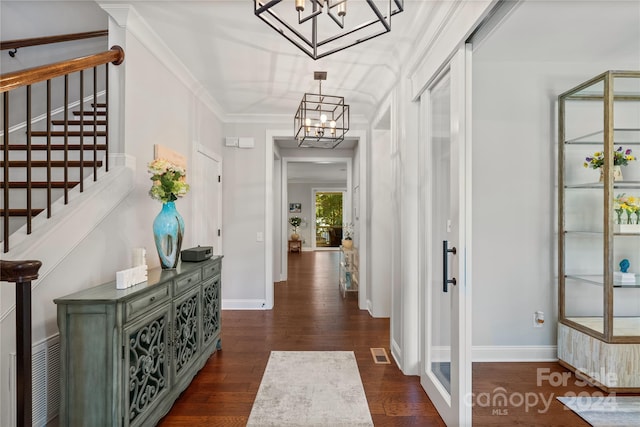 hall with crown molding, dark hardwood / wood-style floors, and an inviting chandelier