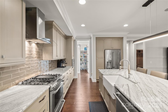 kitchen featuring wall chimney range hood, cream cabinetry, hanging light fixtures, dark wood-type flooring, and high end appliances