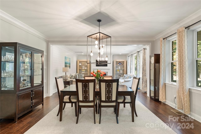 dining area featuring an inviting chandelier, dark wood-type flooring, and crown molding