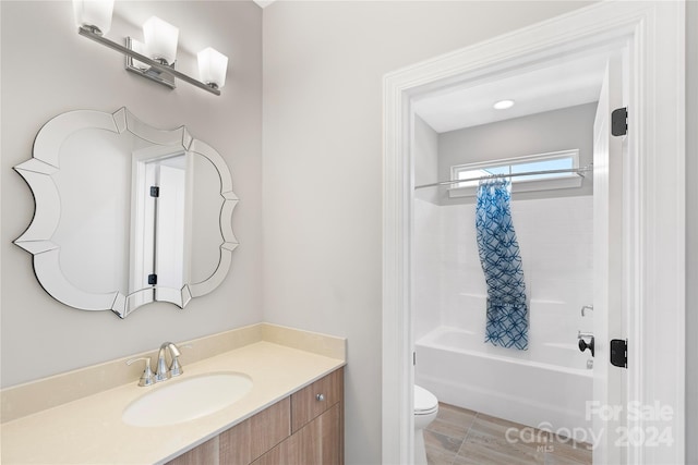 full bathroom featuring vanity, shower / bath combo with shower curtain, and toilet