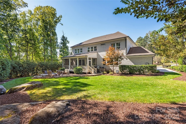 back of house featuring a yard, a patio area, and a sunroom