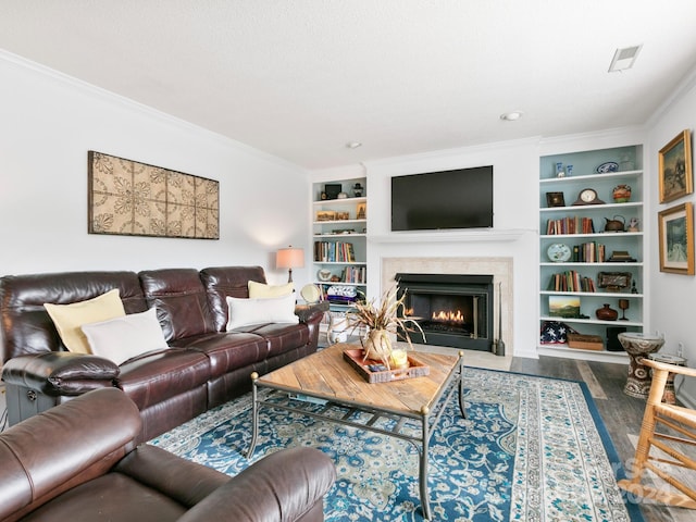 living room with hardwood / wood-style floors, built in features, ornamental molding, and a textured ceiling