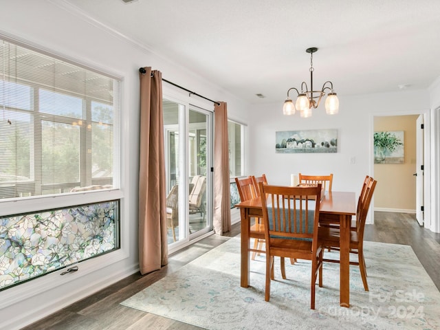 dining space with a chandelier, dark wood-type flooring, and a healthy amount of sunlight