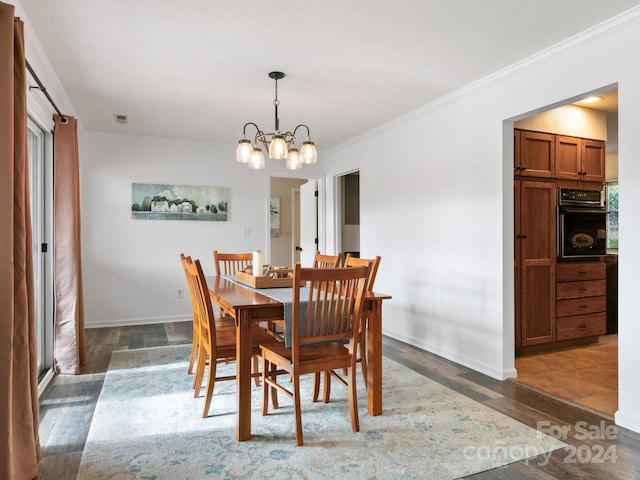 dining area featuring a notable chandelier, crown molding, and dark wood-type flooring