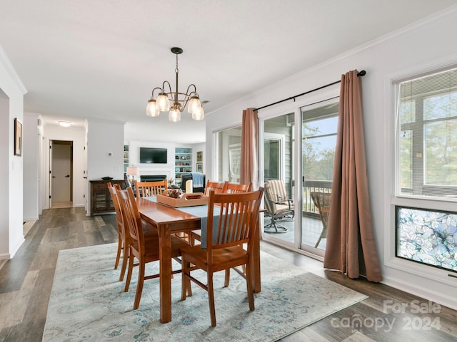 dining room featuring a notable chandelier, plenty of natural light, crown molding, and dark wood-type flooring