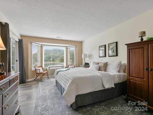 bedroom featuring dark hardwood / wood-style floors and a textured ceiling