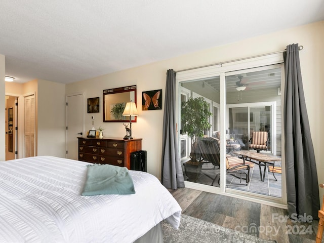 bedroom featuring access to outside, a closet, hardwood / wood-style floors, and a textured ceiling