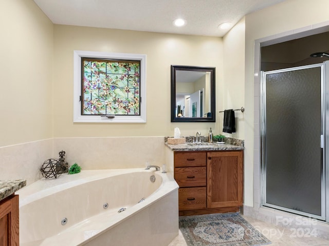 bathroom with vanity, separate shower and tub, and a textured ceiling