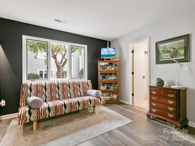 living room with hardwood / wood-style floors and a textured ceiling