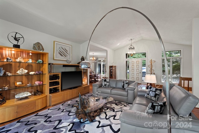 living room with a chandelier and vaulted ceiling