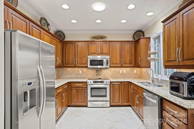 kitchen with tasteful backsplash, light stone countertops, ornamental molding, sink, and stainless steel appliances