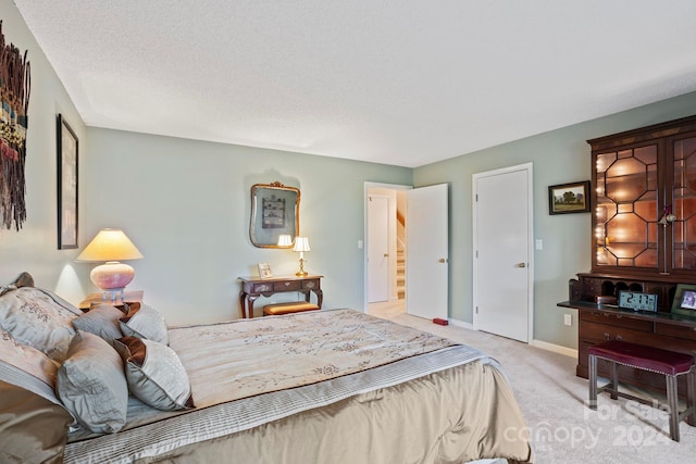 bedroom with light carpet and a textured ceiling