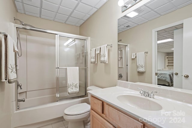 full bathroom featuring vanity, enclosed tub / shower combo, toilet, and tile patterned floors