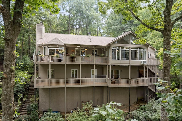 rear view of property with a balcony and a sunroom