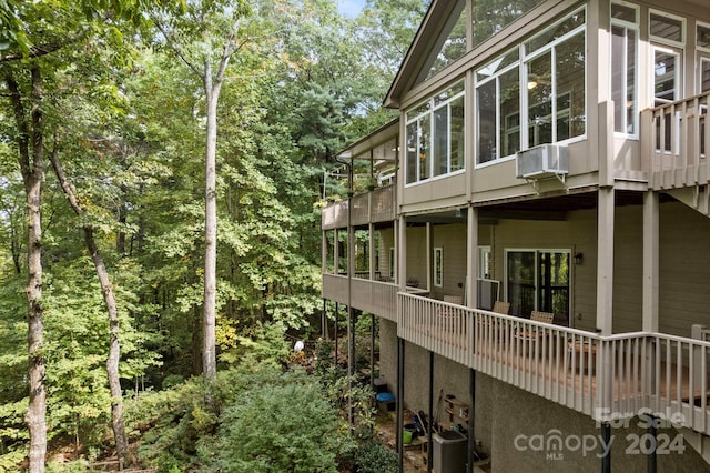 view of side of home with central air condition unit, cooling unit, and a balcony