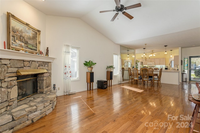 living room featuring vaulted ceiling, a fireplace, hardwood / wood-style flooring, and ceiling fan