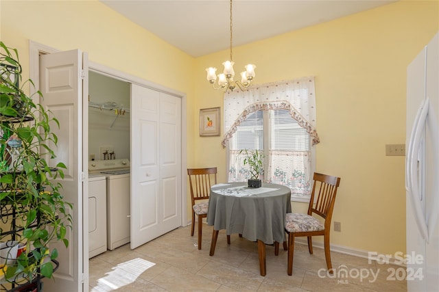 tiled dining room featuring washer and clothes dryer and an inviting chandelier