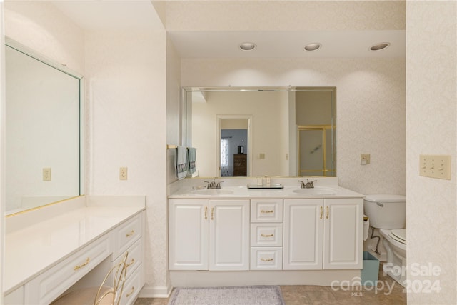 bathroom featuring vanity, tile patterned flooring, toilet, and an enclosed shower