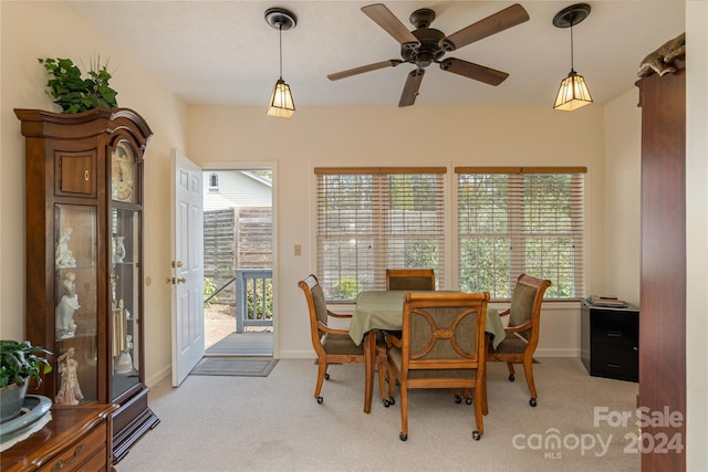 dining room with light carpet, a healthy amount of sunlight, and ceiling fan