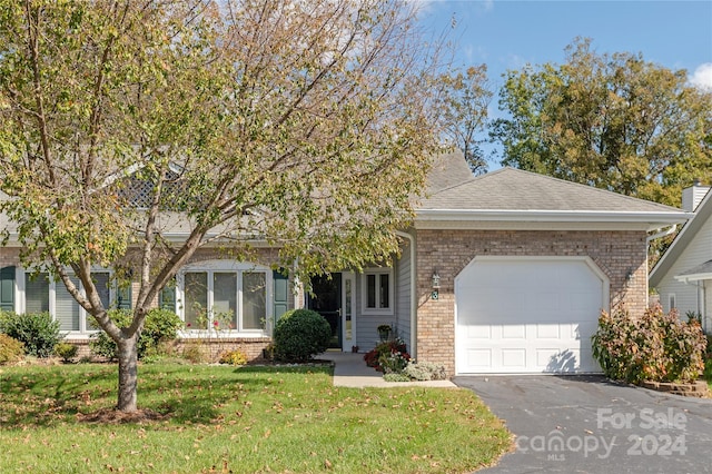 obstructed view of property featuring a front lawn and a garage