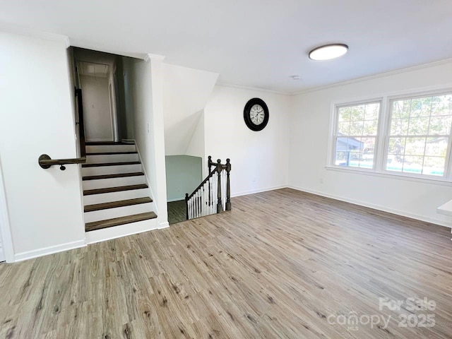 spare room featuring ornamental molding and light hardwood / wood-style flooring