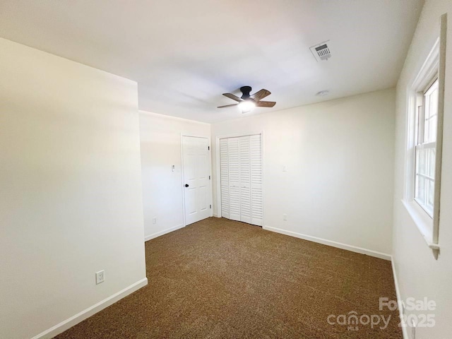 carpeted spare room with ceiling fan