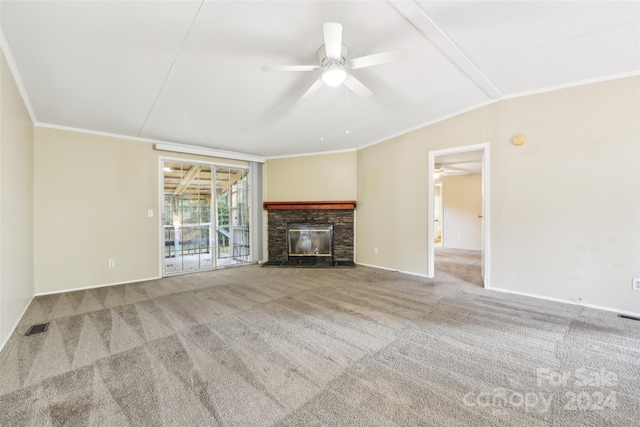 unfurnished living room featuring ceiling fan, a stone fireplace, carpet flooring, and ornamental molding