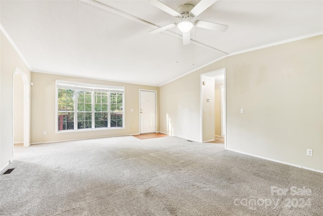 empty room featuring lofted ceiling, crown molding, light carpet, and ceiling fan