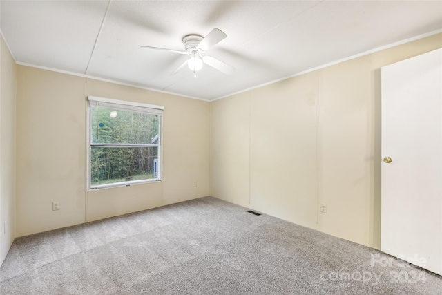 carpeted spare room with ornamental molding and ceiling fan