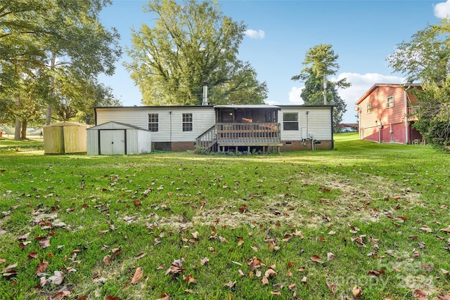 back of house with a yard, a shed, and a sunroom