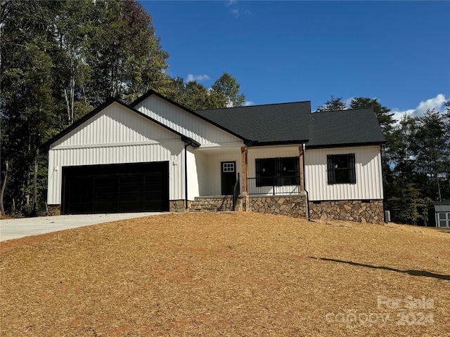 modern farmhouse style home with a porch and a garage