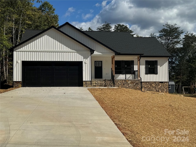 modern farmhouse featuring covered porch and a garage