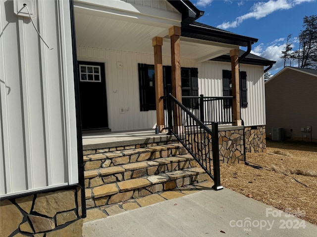 view of exterior entry with a porch and cooling unit