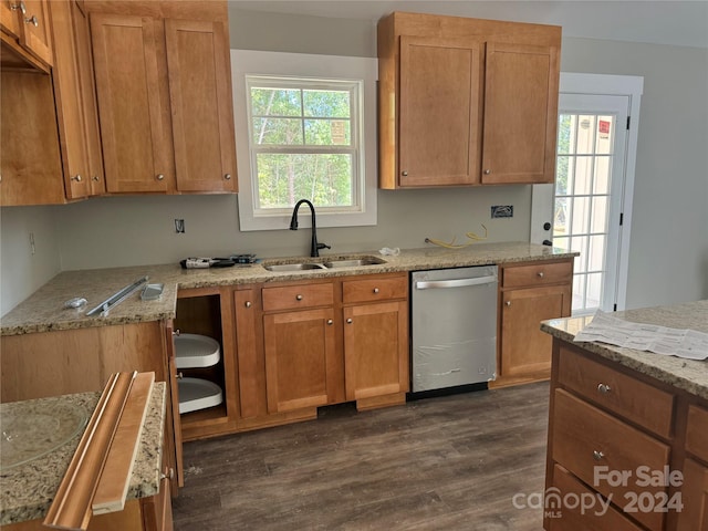 kitchen featuring dishwasher, dark hardwood / wood-style flooring, light stone counters, and sink