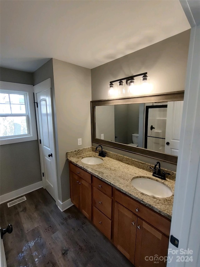 bathroom featuring vanity, hardwood / wood-style flooring, and toilet