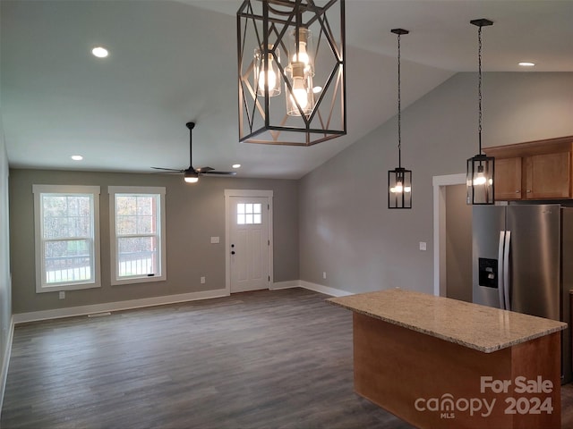 kitchen featuring high vaulted ceiling, ceiling fan with notable chandelier, dark hardwood / wood-style floors, light stone counters, and stainless steel fridge with ice dispenser