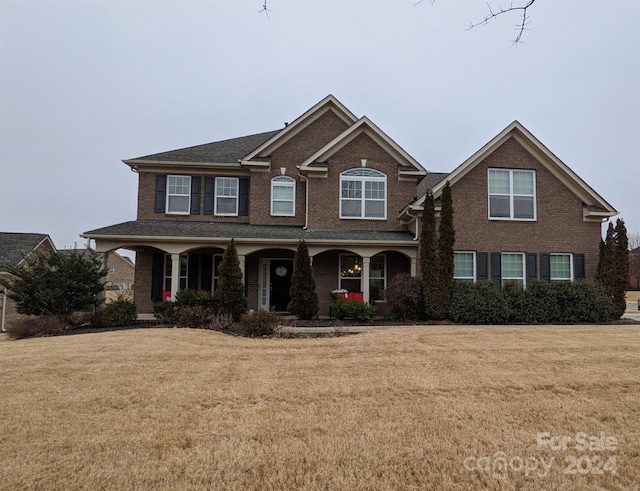 view of front of home with covered porch and a front lawn