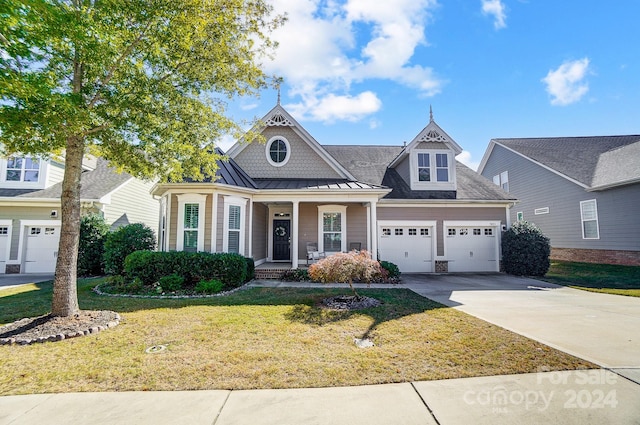 view of front of property with a front lawn, covered porch, and a garage