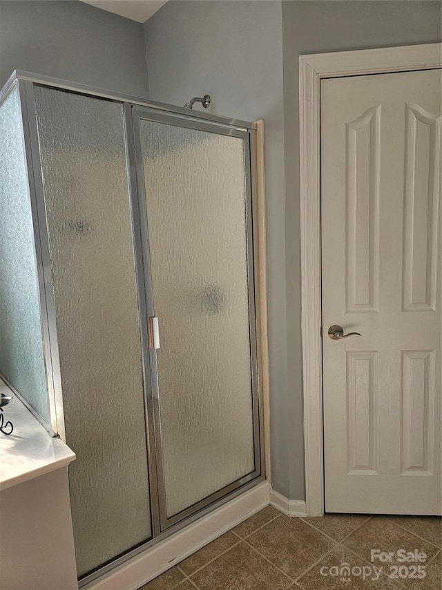 bathroom featuring an enclosed shower and tile patterned flooring