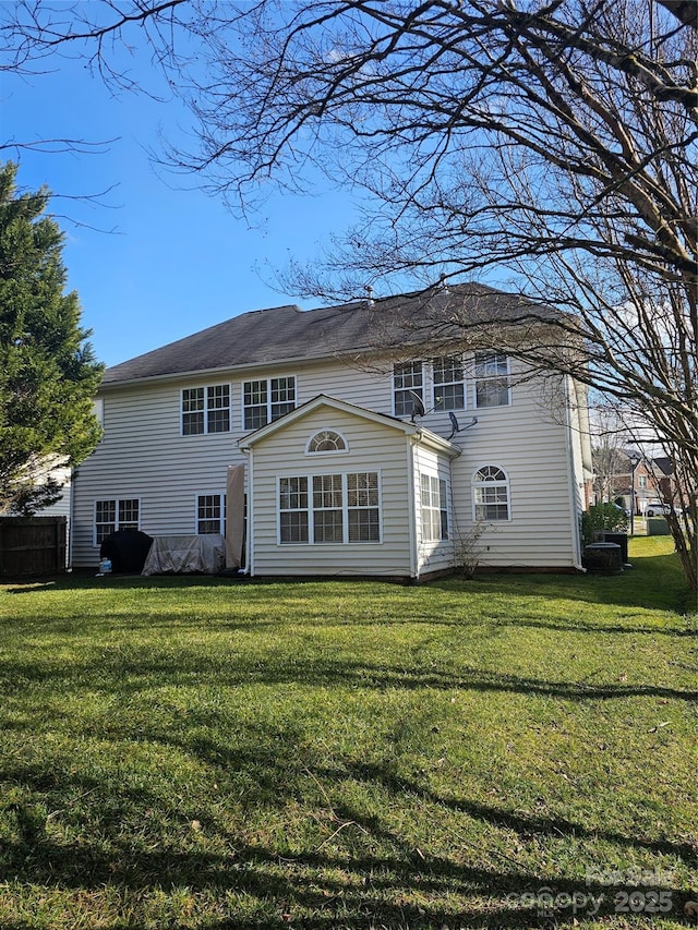 rear view of house featuring a lawn