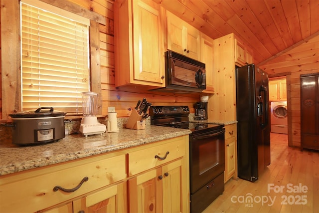 kitchen featuring lofted ceiling, light stone counters, black appliances, light brown cabinetry, and washer / clothes dryer