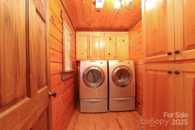 laundry area with cabinets, washer and dryer, wooden ceiling, and wooden walls