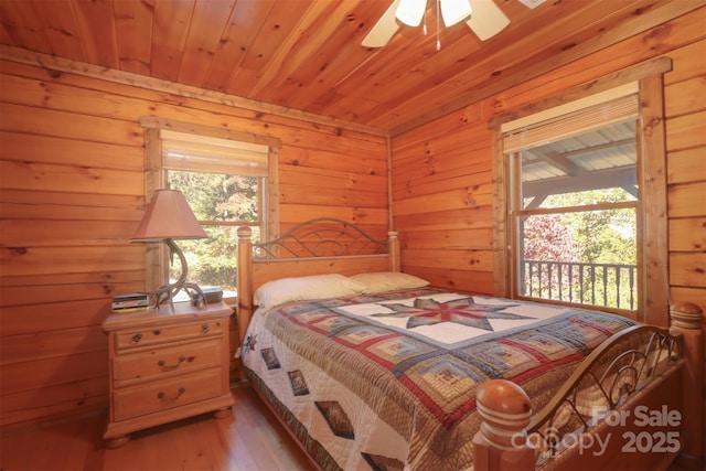 bedroom with wood ceiling, access to exterior, light hardwood / wood-style floors, and multiple windows